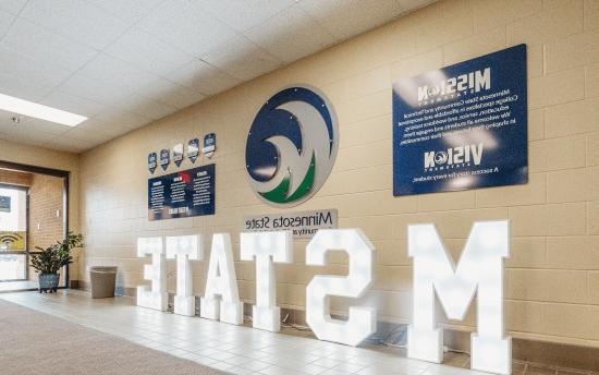 A hallway with many M State branded signs