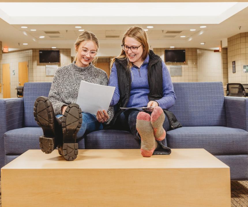 Two students study together in a lounge